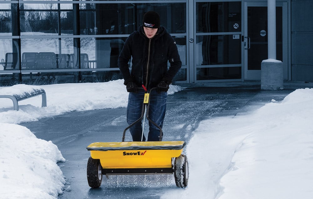 Man pushing a SnowEx spreader