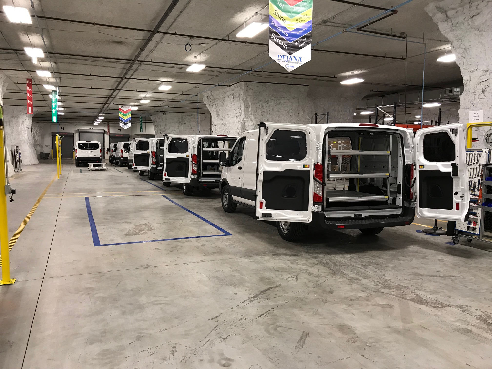A group of vans with their rear doors open
