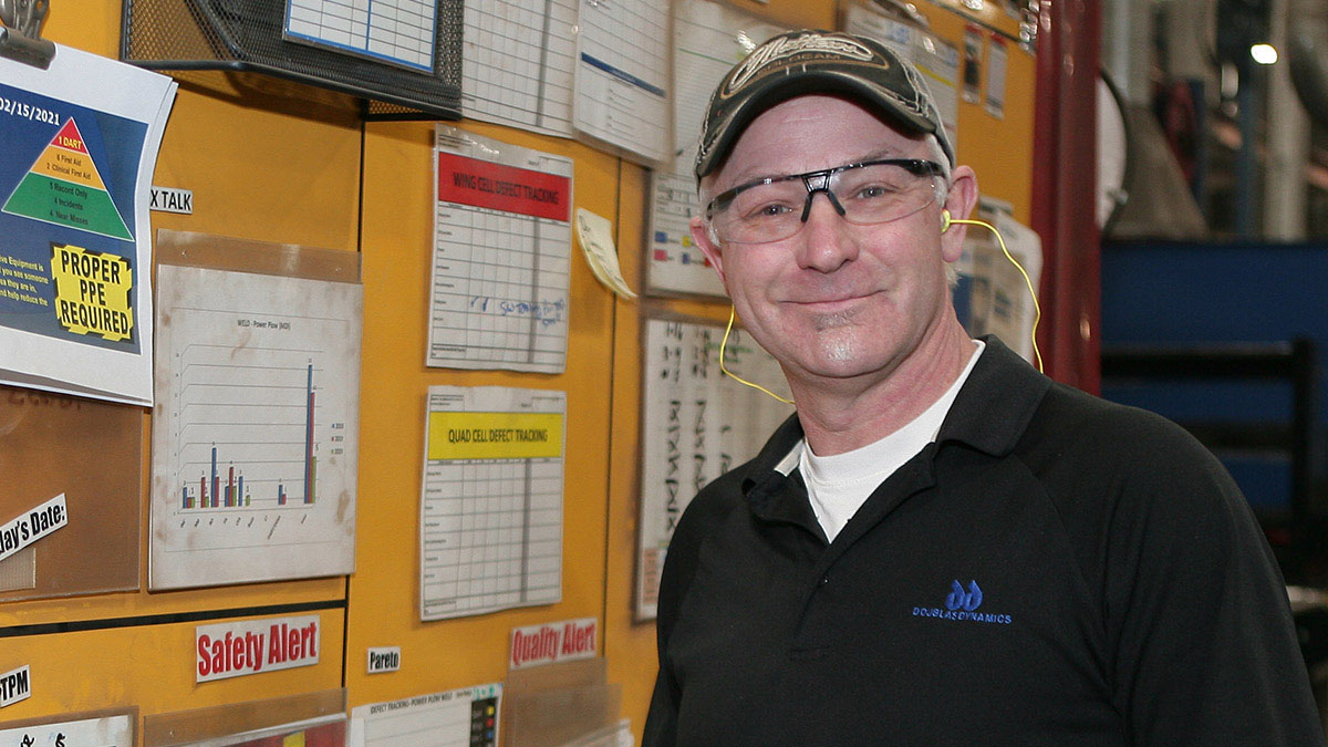 Man in front of work tack board