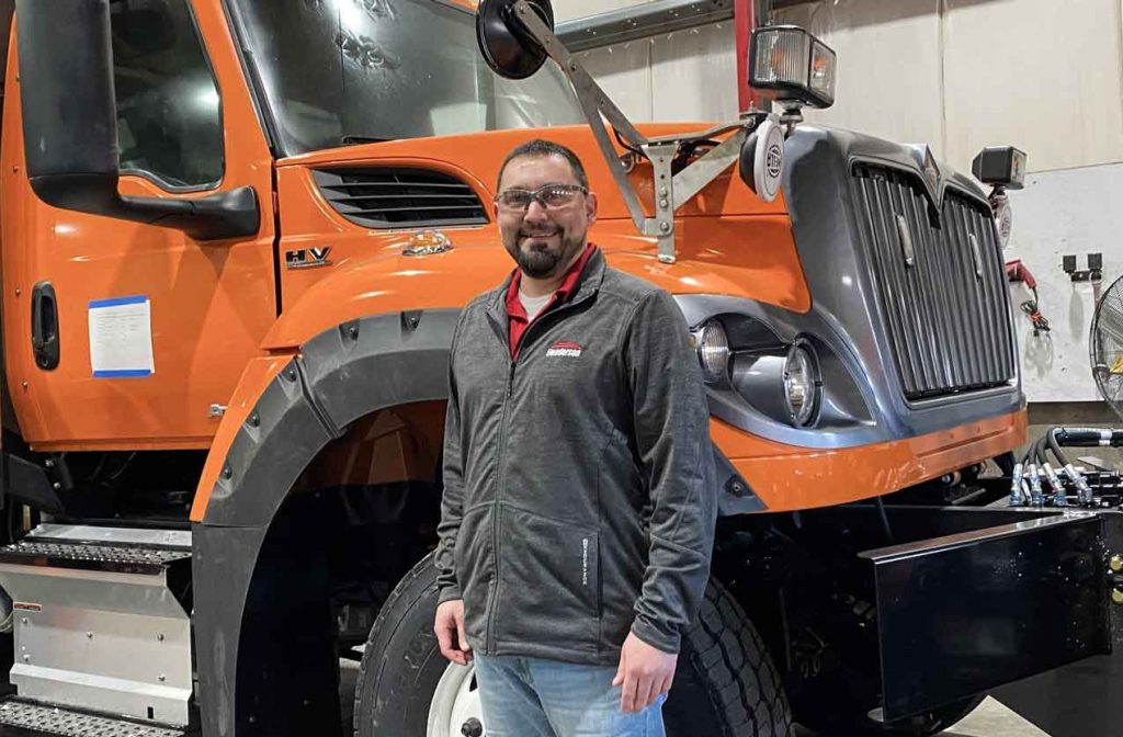 Man in front of Orange Truck