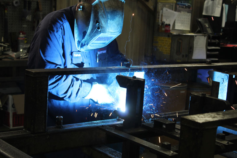 Person welding a plow.