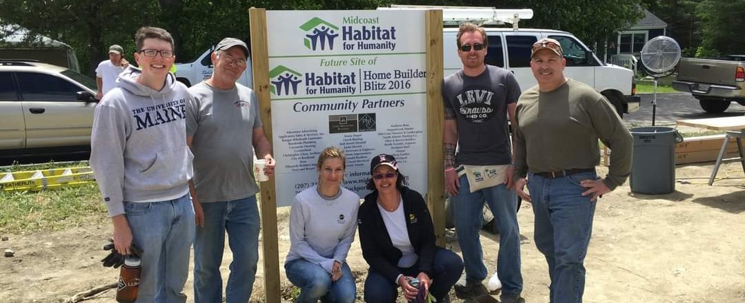 Group of people in front of Habitat for Humanity sign