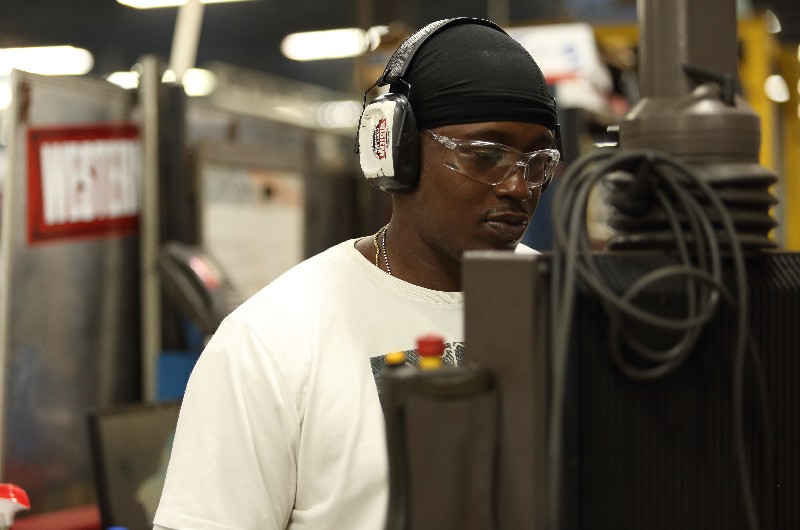 Man using manufacturing equipment while wearing hearing protectiong