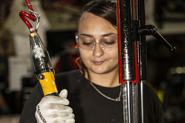 Woman working with a tool with safety glasses on